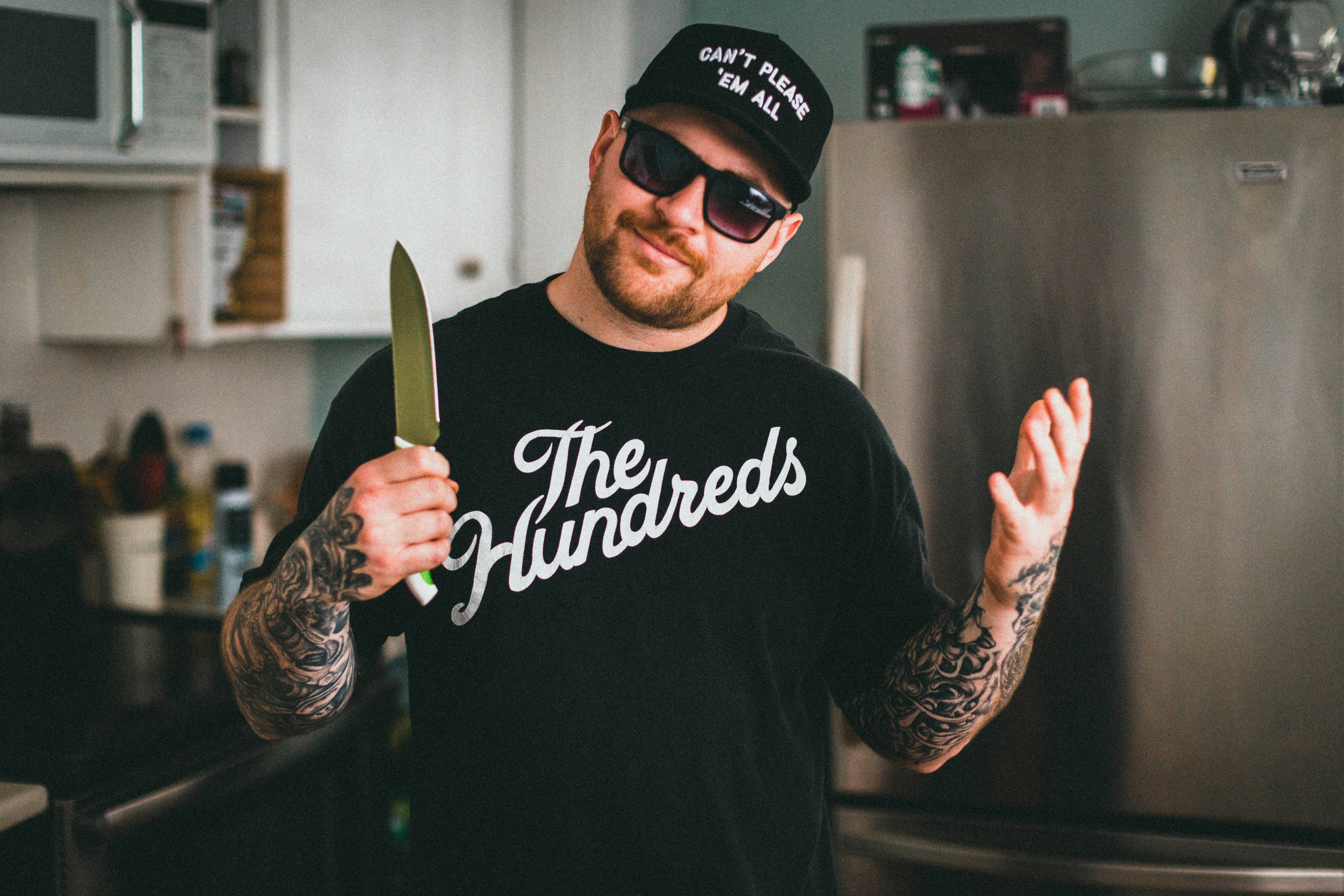 man in black crew neck t-shirt holding knife